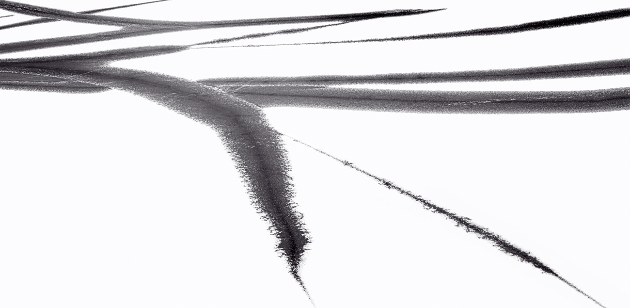 Fine art black and white image of calligraphy-like brush strokes on a frozen lake.