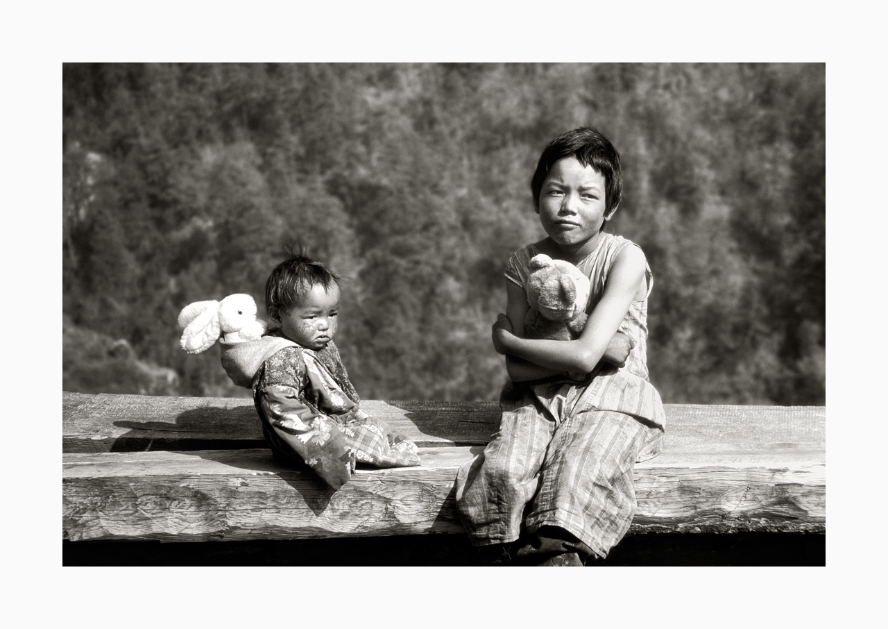 Fine art image of a young girl and infant with pristine stuffed toys, from '90s, Nepal