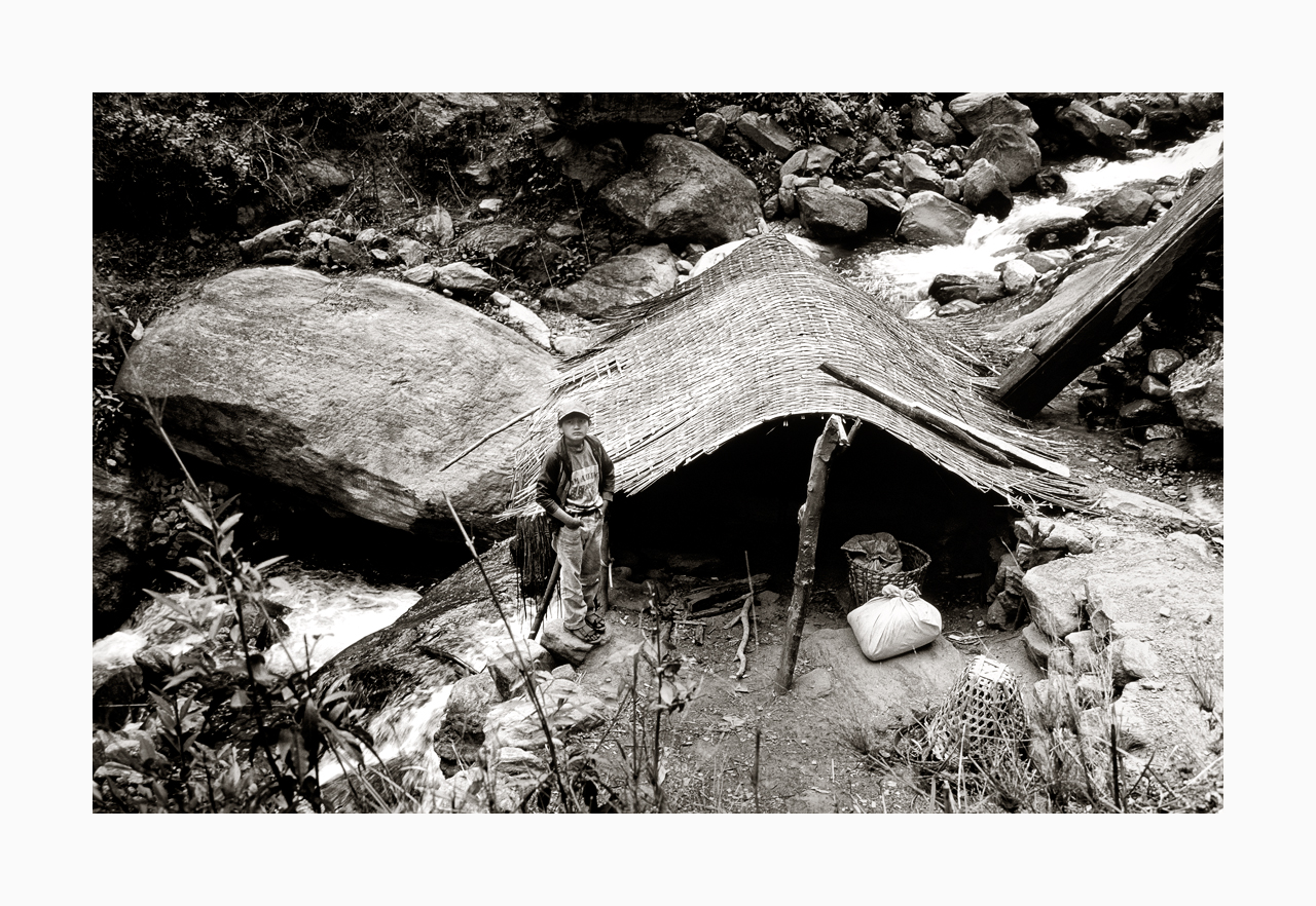 Fine art image of a boy on duty at a hut beside a river, from '90s, Nepal.