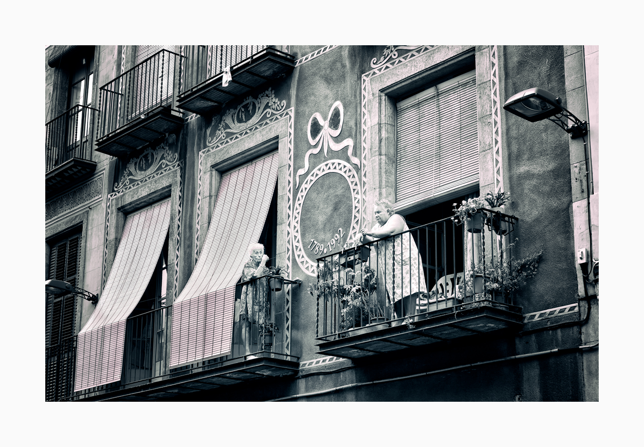 Fine art image of elderly neighbours facing each other on their balconies in Barcelona.